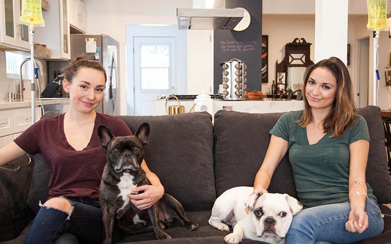 Two women with their dogs receiving IVs at their home
