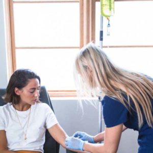 Iron Infusion IV Therapy Blonde nurse giving IV Iron Infusion to her female patient.