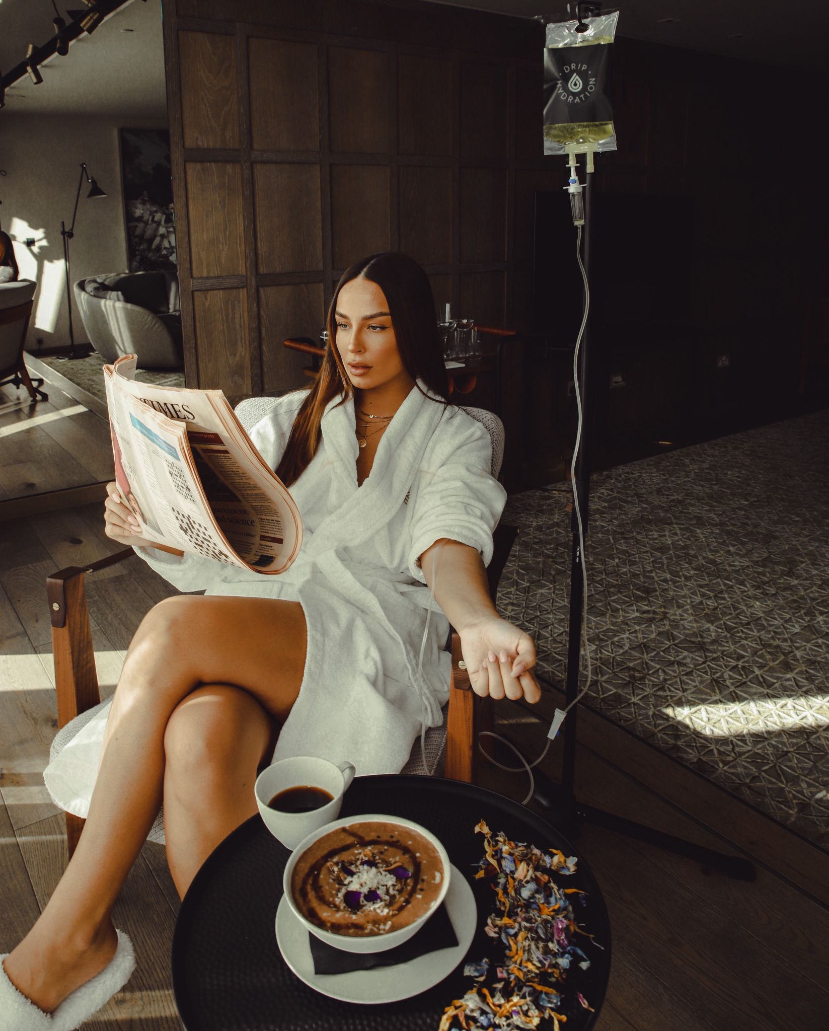 Londoner_Image_#2 woman getting IV therapy in her own home while reading the newspaper and eating breakfast