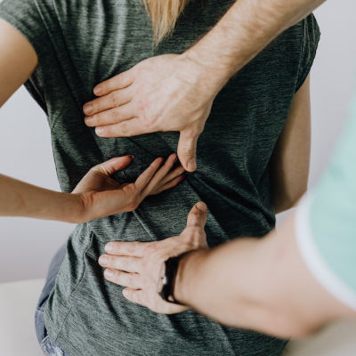 girl with lower back pain explaining to her doctor where the pain is